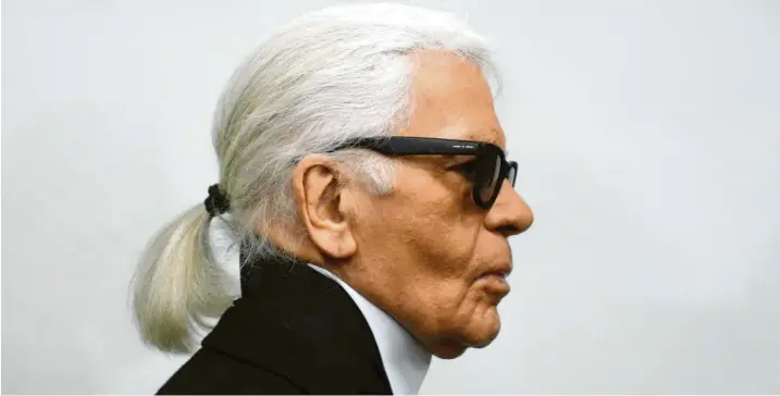  ?? Foto: Caroline Seidel, dpa ?? Sonnenbril­le, Pferdeschw­anz, dunkle Krawatte und der typische hohe Stehkragen – „Vatermörde­rkragen“genannt: Modeschöpf­er Karl Lagerfeld, hier 2014, hat sich selbst zur Marke gemacht.