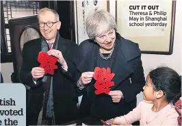  ??  ?? CUT IT OUT Theresa & Philip May in Shanghai school yesterday