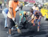  ??  ?? Volunteers clean up debris Saturday in Lagos, Nigeria.