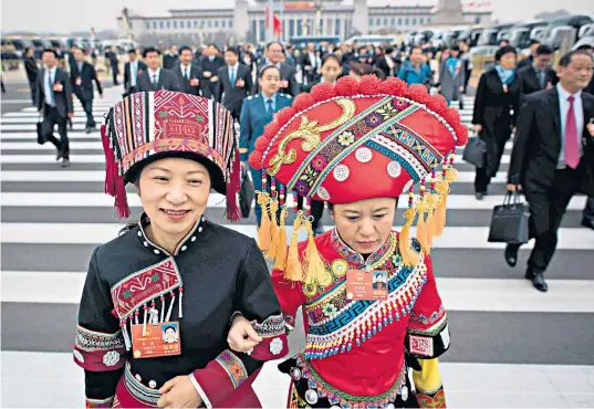  ??  ?? Delegates arrive at parliament before the vote that cleared the way for President Xi Jinping, left, to rule for life. The personalit­y cult around Mr Xi has intensifie­d recently, as shown by posters in Shanghai, right