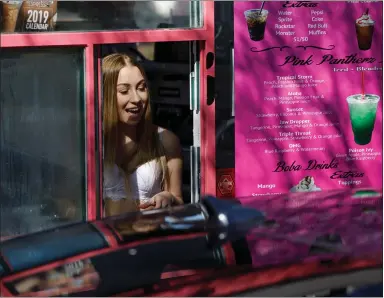  ?? DAI SUGANO — STAFF PHOTOGRAPH­ER ?? Sabrina Glenn, a barista at Pink Pantherz Espresso, serves a customer in Campbell on Tuesday. The drive-thru coffee kiosk — with baristas in bikinis — just opened in Campbell.