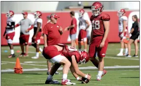  ?? NWA Democrat-Gazette File Photo/ANDY SHUPE ?? Arkansas’ long snapper Jordan Silver (right) watches as Trey Purifoy snaps Tuesday during practice at the university’s practice facility in Fayettevil­le.