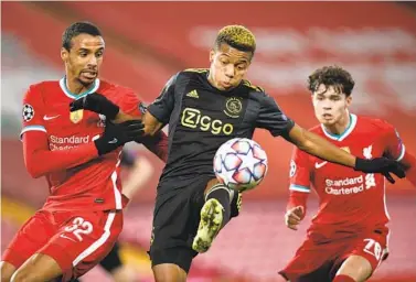  ?? PAUL ELLIS AP ?? Liverpool’s Joel Matip (left) and Neco Williams vie for the ball with Ajax’s David Neres in Champions League match.