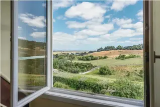  ??  ?? Clockwise from left: Vive la difference with French country bespoke kitchen; a classic combinatio­n of white walls and wooden floors; rural views framed by a dormer window.