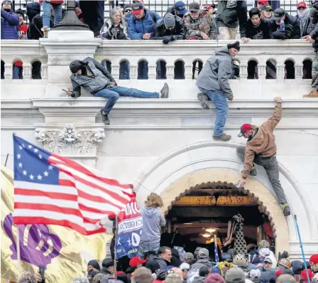  ?? REUTERS ?? A mob of supporters of U.S. President Donald Trump fight with members of law enforcemen­t at a door they broke open as they storm the U.S. Capitol Building in Washington on Jan. 6.