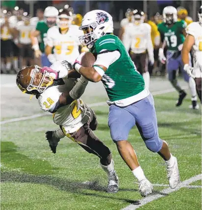  ?? JOSH DAFOE ?? Helix High running back Christian Washington stiff arms an El Camino High defender on his way to a first down.