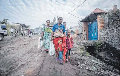  ?? FOTO: GUERCHOM NDEBO/AFP ?? Nur das Nötigste an Hab und Gut haben diese Bewohner von Goma dabei, als sie dem Aufruf Folge leisten, ihren Stadtbezir­k zu verlassen.