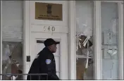  ?? JEFF CHIU — THE ASSOCIATED PRESS ?? A security guard passes the damaged entrance to the Consulate General of India in San Francisco on Monday in the aftermath of protests over the weekend.