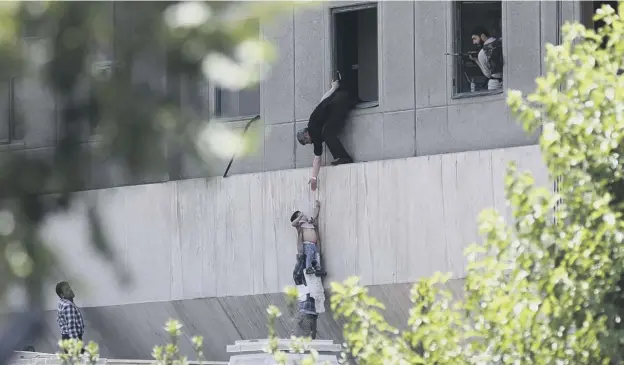  ?? PICTURE: GETTY IMAGES ?? 0 Iranian policemen evacuate a child from the parliament building in Tehran during the attack by Islamic State terrorists