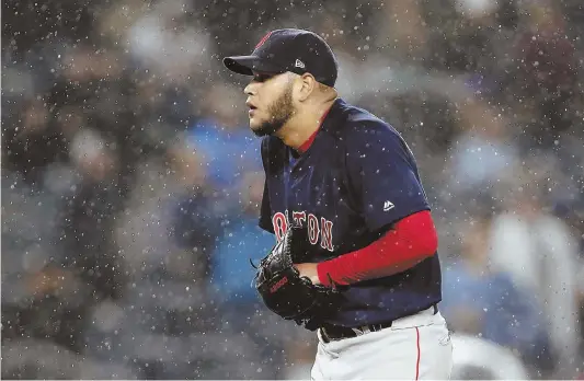  ?? AP PHOTO ?? NO RAINING ON THEIR PARADE: Eduardo Rodriguez reacts as bad weather moves in last night at Yankee Stadium, which delayed the game in the fifth inning. The Red Sox eventually prevailed, 5-4, thanks to a J.D. Martinez tiebreakin­g home run in the eighth.