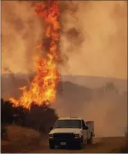  ?? AP PHOTO/JOSH EDELSON ?? A truck passes by flames during the Ranch Fire in Clearlake Oaks, Calif., on Sunday.