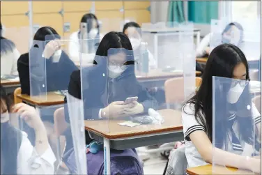  ?? (AP/Yohnap/Kim Jun-beom) ?? Seniors wait behind plastic shields for class to begin Wednesday at a high school in Daejeon, South Korea.