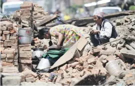  ??  ?? PICKING UP PIECES. Nepalese residents retrieve usable items from the rubble of their collapsed house in Bhaktapur near Kathmandu.