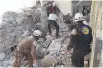  ??  ?? Members of the White Helmets search for survivors.