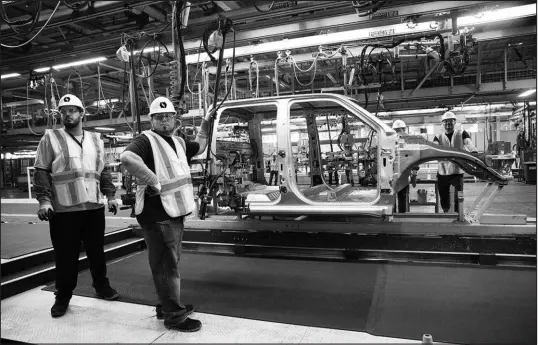  ?? MADDIE MCGARVEY / THE NEW YORK TIMES FILE(2021) ?? Workers are pictured June 21, 2021, on the production line at the Lordstown electric truck plant in Lordstown, Ohio. The Biden administra­tion is proposing rules that would ensure that two-thirds of new cars and a quarter of new heavy trucks sold in the U.S. by 2032 are all-electric.