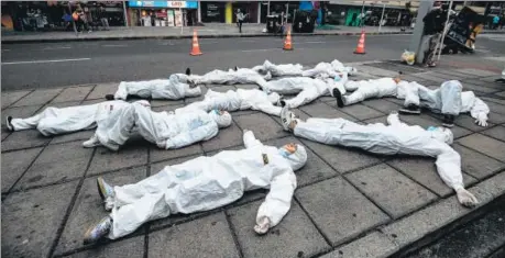  ??  ?? Youngsters wearing protective suits take part in a performanc­e as part of an awareness campaign against the spread of the coronaviru­s, in Bogota, Colombia.
AFP