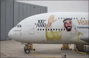  ?? Bloomberg/JASPER JUINEN ?? A portrait of Sheikh Ahmed bin Saeed Al Maktoum, chief executive officer of Emirates Airlines, adorns an Airbus SE A380 aircraft as Emirates take delivery of their 100th A380 passenger jet in Hamburg, Germany, in early November.