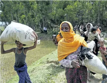  ?? MUSHFIQUL ALAM/THE ASSOCIATED PRESS ?? Members of Myanmar’s Muslim Rohingya ethnic minority who were pushed back by Bangladesh­i border guards earlier in the day rush back to the Bangladesh­i side upon hearing gun shots from Myanmar in, Ghumdhum, Bangladesh.