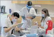  ?? MATT STONE / BOSTON HERALD ?? Walgreens pharmacist­s Bella Farber, Carol D’Souza and Rachael Mann prep COVID-19 vaccines at the Armenian Nursing and Rehabilita­tion Center on Monday in Jamaica Plain.