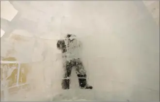  ??  ?? Ice sculptor Julien Doré works on the Big Apple room during the constructi­on of the Snow Village at
Parc Jean-Drapeau.