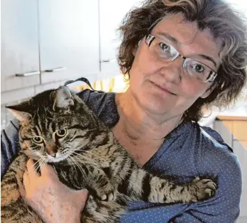  ?? Foto: Alf Geiger ?? Susanne Konrad und ihre Katze „Frieda“, die vor gut zwei Jahren aus dem Haus in der Mozartstra­ße verschwund­en war – und jetzt wieder aufgetauch­t ist. Doch Frieda grämt sich und hat offensicht­lich Sehnsucht nach dem Katzenfreu­nd, bei dem sie die vergan...