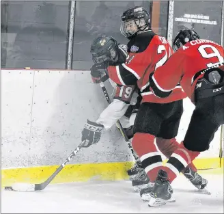  ?? DESIREE ANSTEY/JOURNAL PIONEER ?? Kensington Wild forward Duncan Picketts, 19, battles against the Moncton Flyers’ Keegan Hunt and Alex Cormier, 9, during a New Brunswick/P.E.I. Major Midget Hockey League game at Credit Union Centre in Kensington on Saturday night.