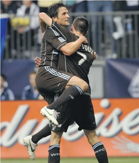  ?? ARLEN REDEKOP/PNG FILES ?? John Thorringto­n, left, then playing for the Whitecaps, hugs goal-scorer Sebastien Le Toux at a B.C. Place game in 2012. Thorringto­n has a good idea of what to expect in the early years of an expansion franchise as executive vice-president of soccer...