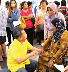 ??  ?? Dr Sim interacts with a member of the public who attended the free TCM health screening.