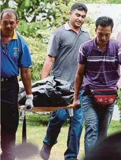  ??  ?? ANGGOTA polis mengusung mayat pencuci rumah sambilan warga Indonesia.