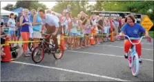  ??  ?? Montgomery County Commission­ers Chairman Josh Shapiro and District Attorney Risa Vetri Ferman have fun racing on children’s bikes during Franconia’s National Night Out.