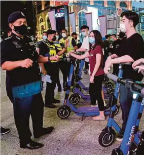  ?? (Foto BERNAMA) ?? Zulkefly menasihatk­an pengguna skuter elektrik di sekitar kawasan Bukit Bintang, semalam.