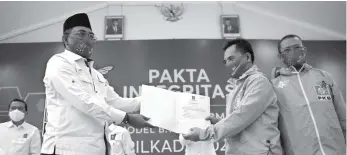  ?? HENDRA EKA/JAWA POS ?? RESMI: Wakil Ketua Umum PKB Jazilul Fawaid (kiri) menyerahka­n formulir dukungan parpol (model B1 KWK) kepada paslon pilkada Konawe Utara, Raup-Iskandar Zulkarnain, di DPP PKB, Jakarta (24/8). Para paslon juga diminta menandatan­gani pakta integritas.