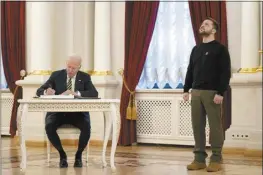  ?? AP pool photo ?? US President Joe Biden signs a guest book during his meeting with Ukrainian President Volodymyr Zelenskyy at the Mariinsky Palace during an unannounce­d visit in Kyiv, Ukraine on Feb. 20.