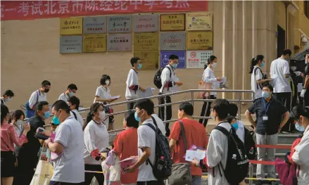 ?? ANDY WONG/AP 2022 ?? Students line up to enter a school for the first day of China’s national college entrance examinatio­ns, known as the gaokao, in Beijing.