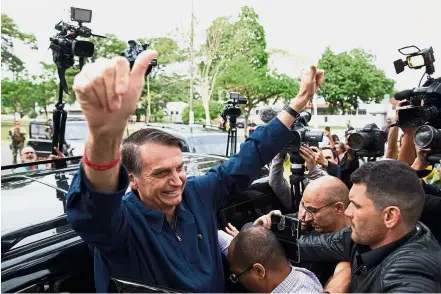  ??  ?? Feeling confident: Bolsonaro giving the thumbs-up after casting his vote at Villa Militar, during general elections, in Rio de Janeiro.