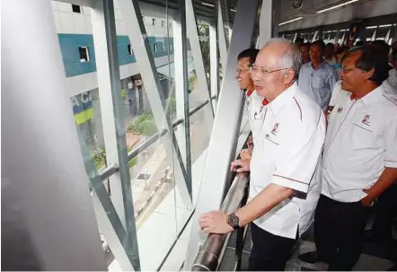  ??  ?? Convenient way: Najib accompanie­d by Raja Nong Chik and Ahmad Fuad at the launch of the KLCC-BUKIT Bintang walkaway.