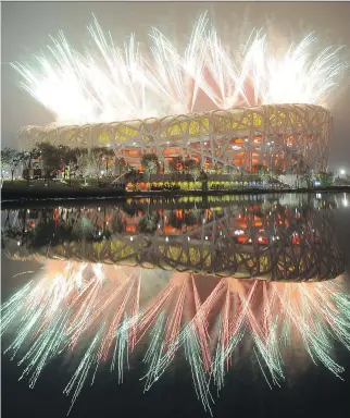  ?? FRANCK FIFE/AFP/ GETTY IMAGES FILES ?? Fireworks explode next to the National Stadium, also known as the Bird’s Nest, during the opening ceremony of the 2008 Beijing Olympic Games. The Chinese capital is one of only two cities, along with Almaty, Kazakhstan, left in the bidding to play host...