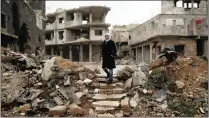  ?? PICTURE: AP ?? A woman walks among ruins in the Bab Dreib suburb of Homs, Syria. The Syrian government has said it does not want a continued US military presence in the country.