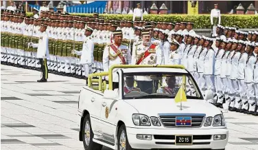  ?? — Bernama ?? Royal celebratio­n: Sultan Muhammad V (right) and Ahmad Hasbullah inspecting the guard of honour during the Trooping the Colour ceremony at Dataran Pahlawan Negara.