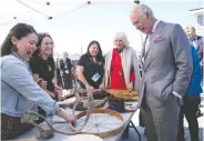  ?? PAUL CHIASSON / THE CANADIAN PRESS ?? Prince Charles and Camilla, Duchess of Cornwall, look at a display of traditiona­l hunting tools and clothing after arriving in Yellowknif­e during the royal tour Thursday.