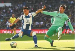  ??  ?? Historic... Espanyol’s Wu Lei (left) gets the better of Sergio Ramos and Real Madrid