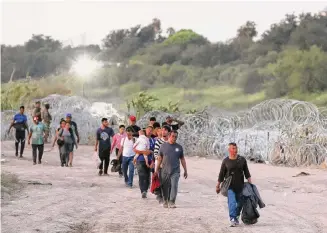  ?? Jerry Lara/Staff photograph­er ?? In his latest legal challenge to Border Patrol filed Friday, Attorney General Ken Paxton suggests that Hamas terrorists could cross the border among migrants like these at Eagle Pass.