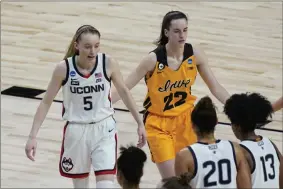  ?? THE ASSOCIATED PRESS ?? UConn guard Paige Bueckers (5) and Iowa guard Caitlin Clark (22) walk off the court after their college basketball game in the Sweet Sixteen round of the women’s NCAA tournament at the Alamodome in San Antonio, Saturday, March 27, 2021.