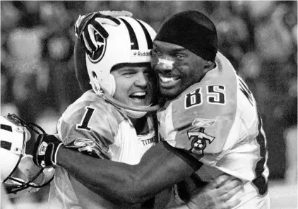  ?? RUSTY KENNEDY/AP ?? Titans WR Derrick Mason, right, hugs K Gary Anderson after hitting a 46-yard FG in their playoff matchup with the Ravens in 2004.