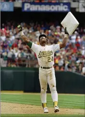  ?? ASSOCIATED PRESS FILE ?? The A’s Rickey Henderson raises third base after recording his 939th steal to break Lou Brock’s all-time record in May of 1991.