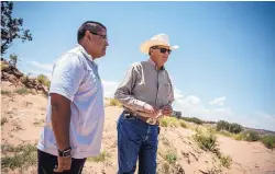  ??  ?? Zia Pueblo Lt. Gov. Jerome Lucero, left, and state Land Office Commission­er Aubrey Dunn announce a joint initiative by the pueblo and the land office to clean up an illegal dump site and install a fence.