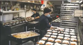  ?? (AP/Charles Rex Arbogast) ?? Cooks Jose Robledo (left) and Maria Cruz prepare meals that will be delivered to I Grow Chicago, in the Englewood neighborho­od of Chicago.