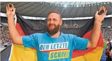  ?? FOTO: STACHE/DPA ?? Diskuswerf­er Robert Harting verabschie­det sich nach seinem letzten Karriere-Wettkampf mit der Deutschlan­d-Fahne von den Fans.