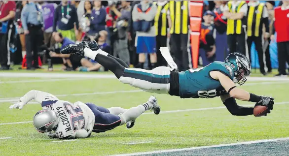  ?? FRANK FRANKLIN II/THE ASSOCIATED PRESS ?? Philadelph­ia tight end Zach Ertz dives into the end zone over New England free safety Devin McCourty for the game-winning touchdown.