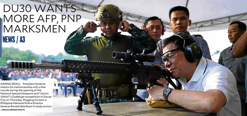  ?? —MALACAÑANG­PHOTO ?? AIMING SMALL President Duterte checks his marksmansh­ip with a few rounds during the opening of the National Special Weapons and Tactics (SWAT) Challenge competitio­n in Davao City on Thursday. Plugging his ears is Philippine National Police Director General Ronald dela Rosa (in body armor).